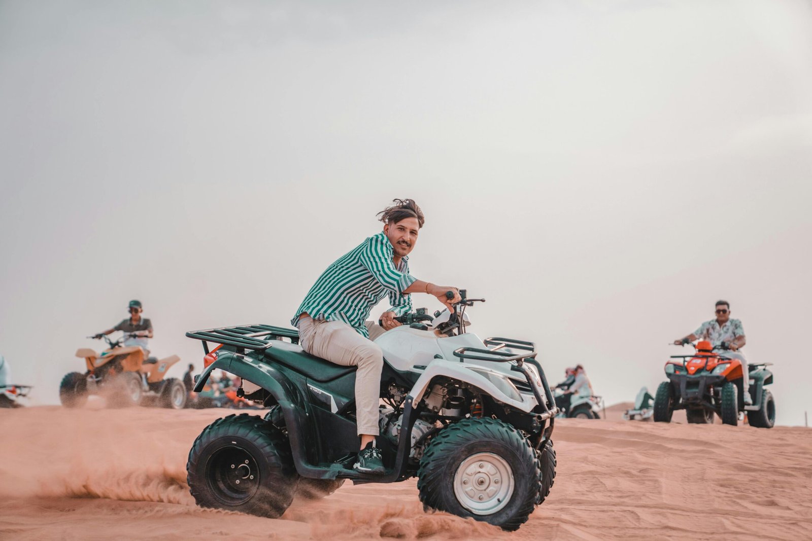 Group riding quads in a vast desert landscape, exuding adventure and excitement.