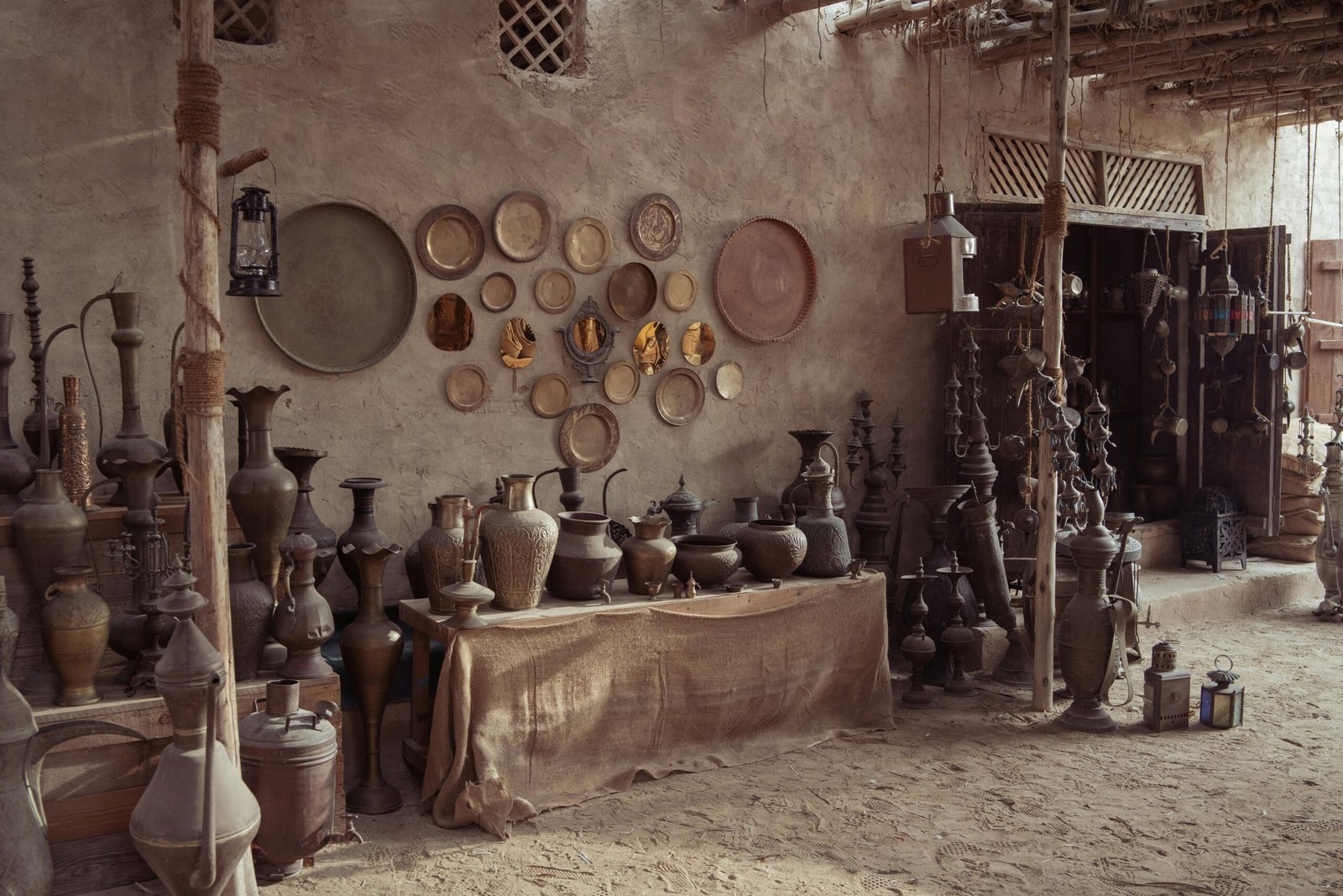 Rustic pottery shop with Middle Eastern artifacts and decor in a dimly lit indoor setting.